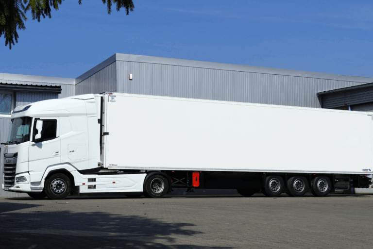 Ciężarówka z naczepą chłodniczą firmy S&M Logistic gotowa do załadunku pod magazynem – transport chłodniczy międzynarodowy z siedzibą w Poznaniu.