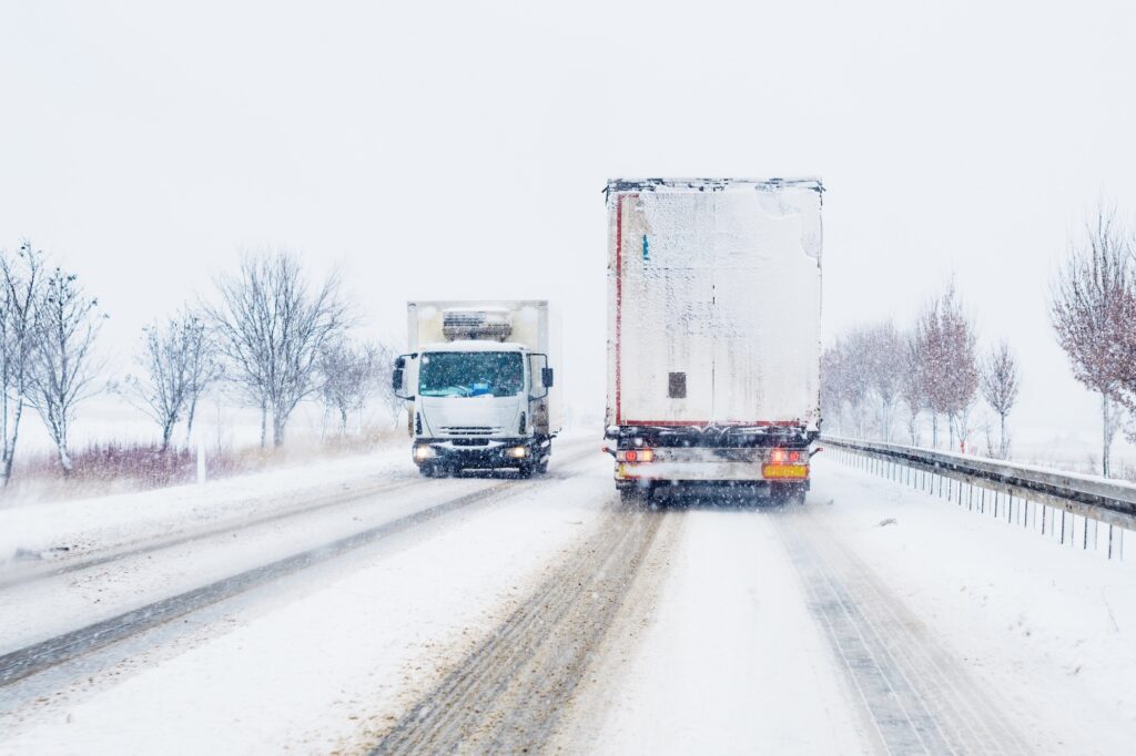 Freight transportation truck on the road in snow storm blizzard